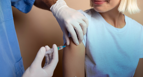 Profesional de la salud aplicando una vacuna en un vacunatorio